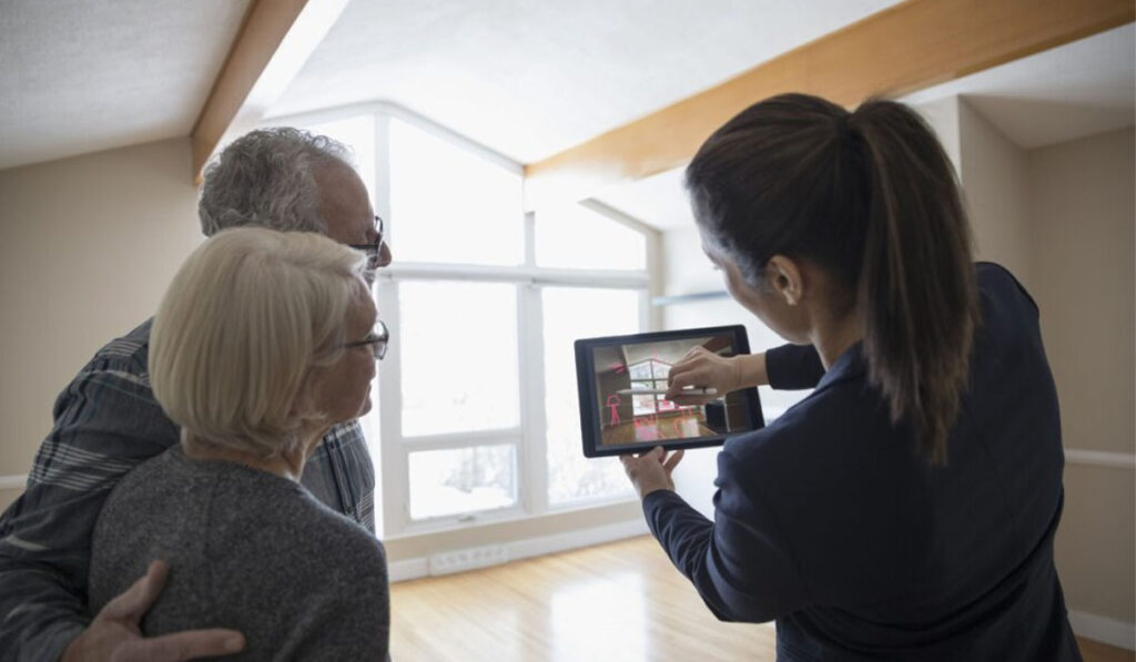 woman showing a couple an interior design on a tablet