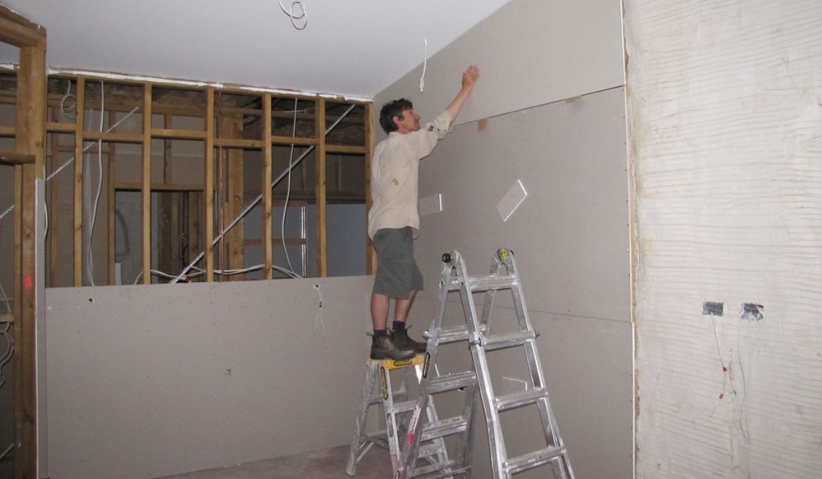 a contractor repairing drywall in a renovation area